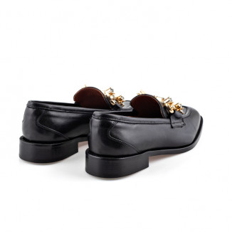 Black smooth leather moccasin with decorative stitching on the toe and golden application